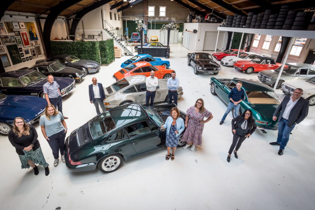 Groepsfoto met auto's tijdens het Driver of the Day evenement georganiseerd door Brancheteam Transport & Logistiek van WSP Holland Rijnland